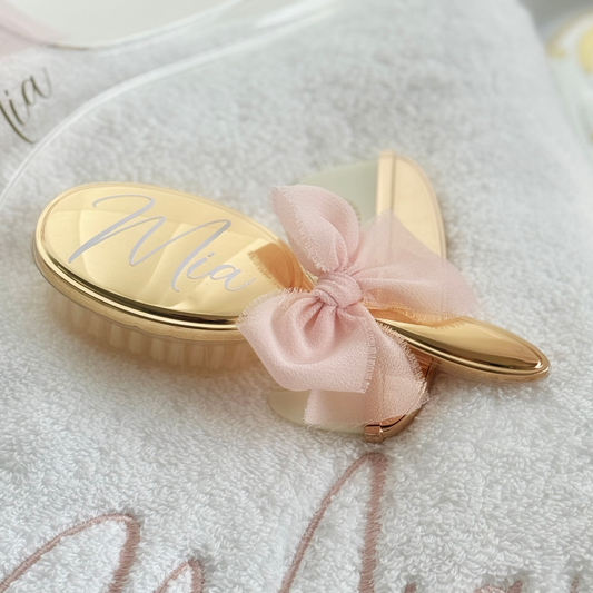 Gold personalised hairbrush with a pink bow on a white background - christening gift 
